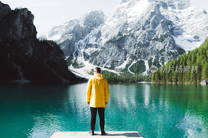 身穿雨衣的男人在Dolomites阿尔卑斯山的Lago Di braes享受夏天的早晨